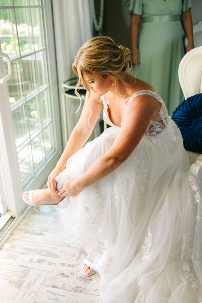 bride securing her heels in the bridal suite