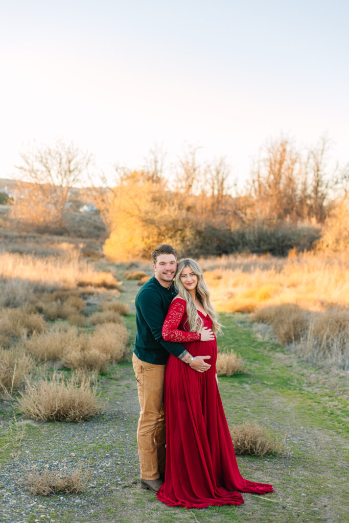 man and woman standing in the brush for their maternity photos in washington